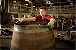 Young man making whisky cask at cooperage