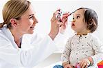 Paediatrician checking baby boy's eyes