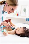 Paediatrician checking baby boy's heart using stethoscope