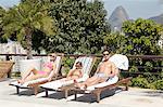 Young family sunbathing by pool, Rio de Janeiro, Brazil