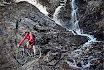 Mountain biker cycling over rocks