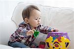 Baby boy playing with shape sorter toy