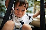 Portrait of smiling boy sat between railings