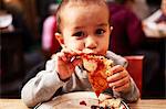 Boy eating pizza in restaurant