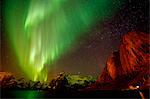 View of aurora borealis over sea and snow capped mountains, Reine, Norway