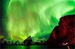 View of green aurora borealis over sea and mountains, Reine, Norway