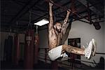 Male boxer training on bar in gym