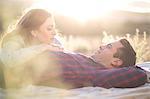 Young couple lying outdoors on blanket relaxing