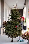 Girl carrying a christmas tree