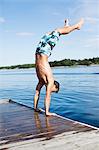 Teenage boy doing handstand on jetty