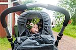 Baby in buggy wearing flower wreath