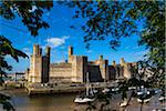 Boats at low tide in front of Caernarfon Castle, Caernarfon, Gwynedd, Wales, United Kingdom