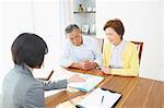 Senior Japanese couple consulting with financial planner