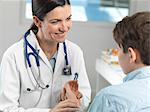 Doctor checking pulse of young boy in clinic