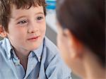 Doctor comforting young boy in clinic