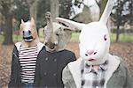 Three sisters wearing animal masks posing in park