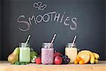 Still life of three fresh smoothies in front of blackboard