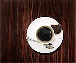 Overhead view of a black coffee on wooden table