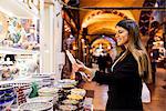 Young woman looking at crockery on market stall, Istanbul, Turkey