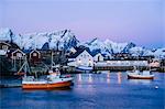 Reine fishing village at dusk with snow capped mountains, Norway