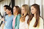 Row of five girls and boys looking out from shelter