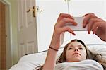 Girl lying on bed reading smartphone text messages