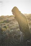 Mid adult man strolling in sunlit field