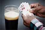 Man holding four ace cards with beer