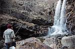 Man fishing by waterfall, River Toce, Premosello, Verbania, Piedmonte, Italy