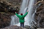 Man by waterfall arms out, Toce River, Premosello, Verbania, Piedmonte, Italy