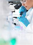 Female scientist pipetting sample into a vial for analytical testing in a laboratory