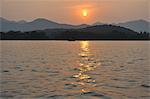 Sunset over lake, mountains in distance, Hangzhou, China