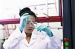 Female scientist using pipette and volumetric flask in lab