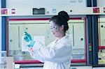 Female scientist in lab pipetting sample into lab beaker