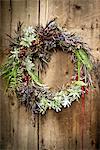 Christmas wreath with foliage and berries on wooden door