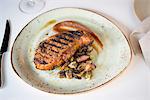Plate with grilled meat on restaurant table