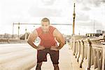 Male runner taking a break on bridge, Los Angeles, California, USA