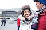 Couple talking while walking in city during winter