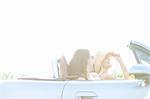 Happy female friends enjoying road trip in convertible on sunny day