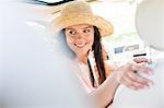 Happy woman looking back while driving car