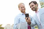 Businessmen using mobile phone against clear sky