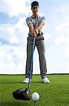 Man about to strike golf ball, low angle view