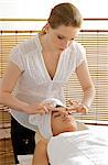 Young woman receiving head massage from masseuse