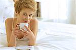 Woman drinking coffee in bed