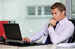 Businessman sitting with laptop at office