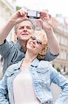 Happy middle-aged couple taking self portrait outdoors