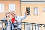 Happy man showing something to woman with guidebook in city