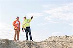 Low angle view of supervisor showing something to colleague at construction site