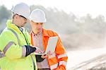 Supervisors using laptop at construction site