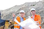 Engineers discussing over blueprint at construction site